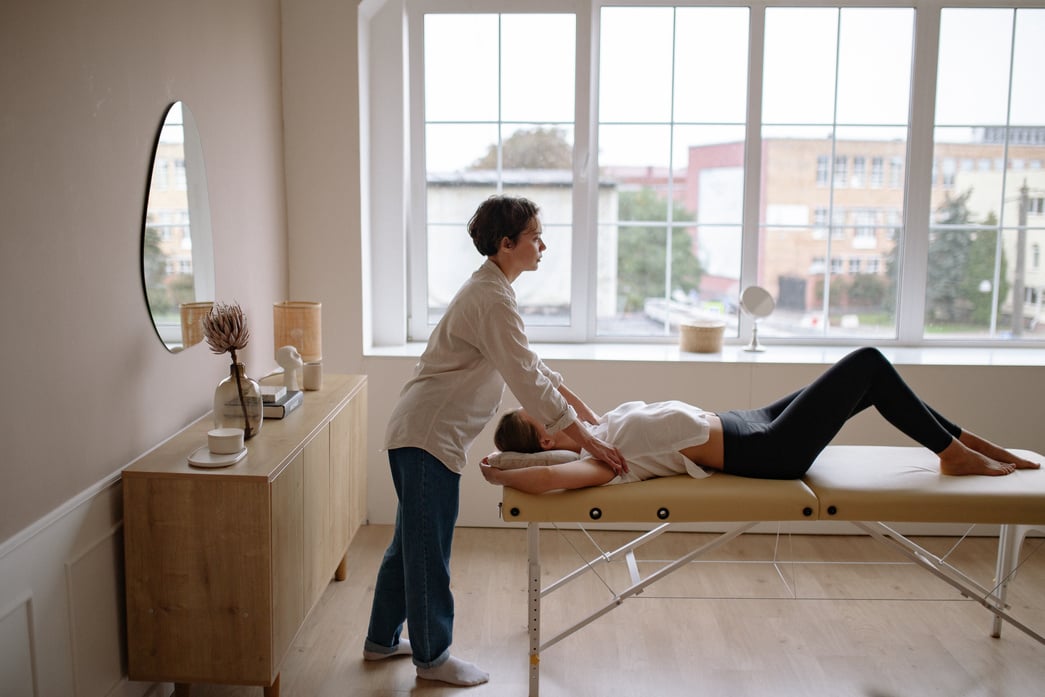 A Massage Therapist Massaging a Woman on a Massage Table